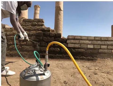 Figure 37: The conservator during the consolidation of old mud brick walls by ethyl silicates using the dispenser (a, b).