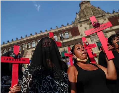 Fig. 1: Women hold crosses at a protest against femicide and violence against women in front of the National Palace in Mexico City, Mexico. ©REUTERS/ Edgard Garrido