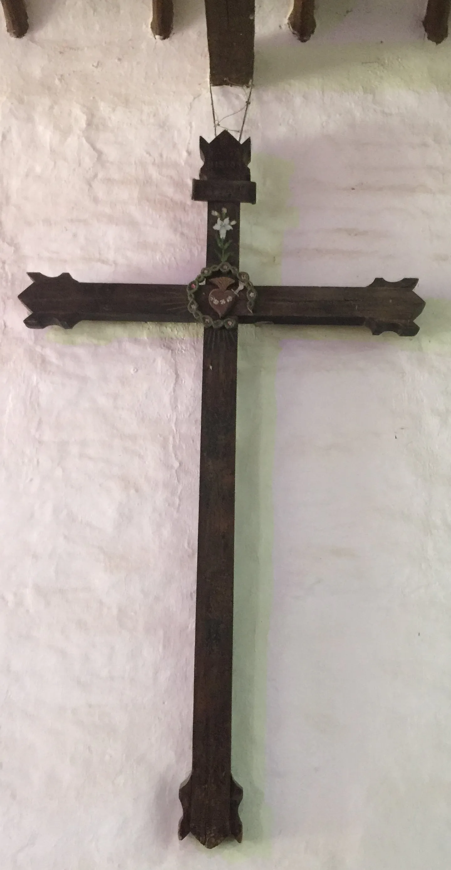 Cruz de altar antigua en madera con medallón floral en el crucero