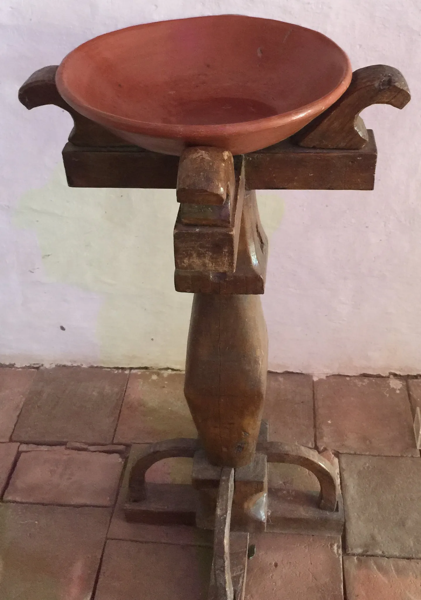 Pila bautismal histórica con pedestal tallado y cuenco en barro cocido