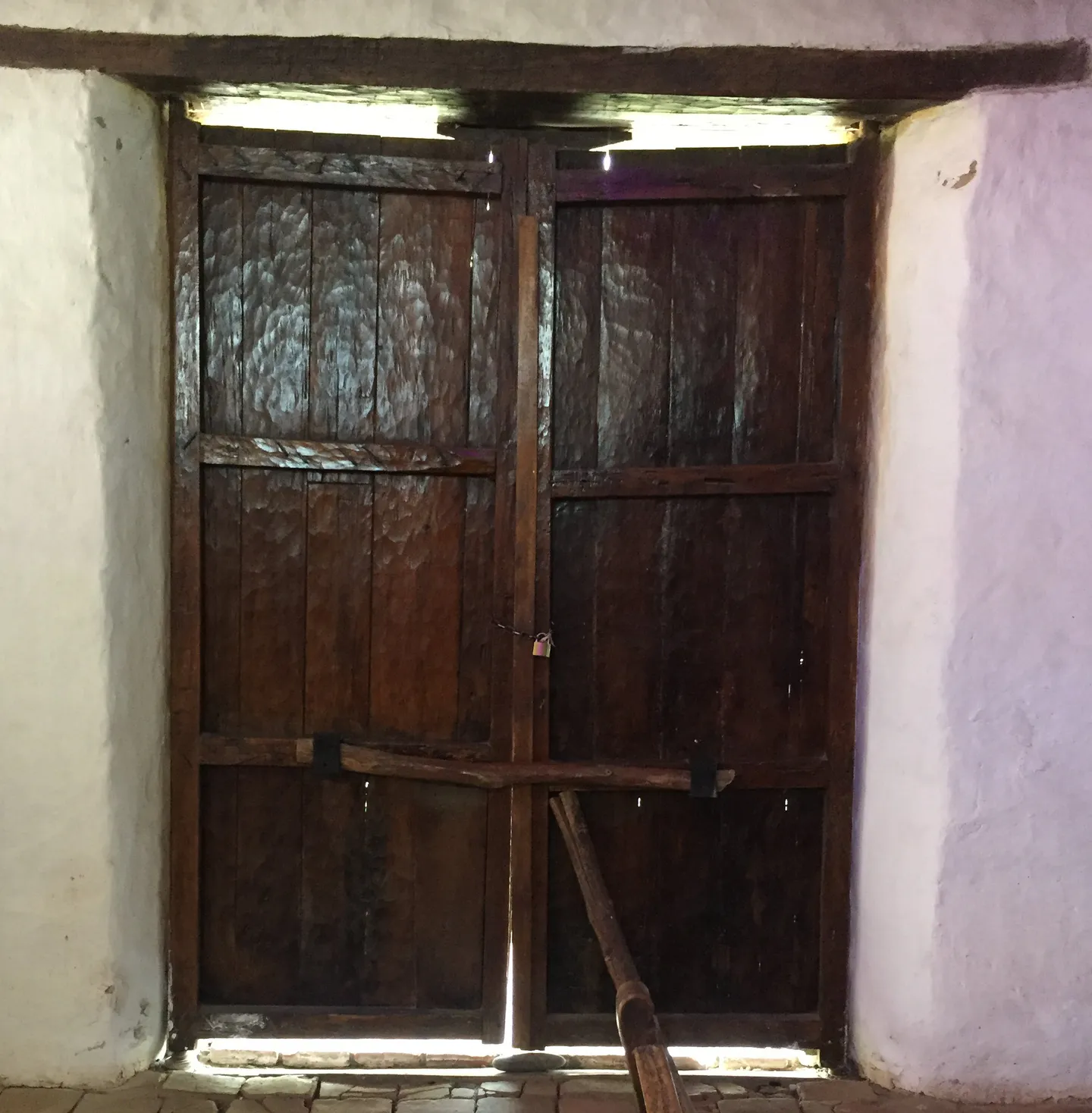 Portón principal de dos batientes de madera visto desde el interior