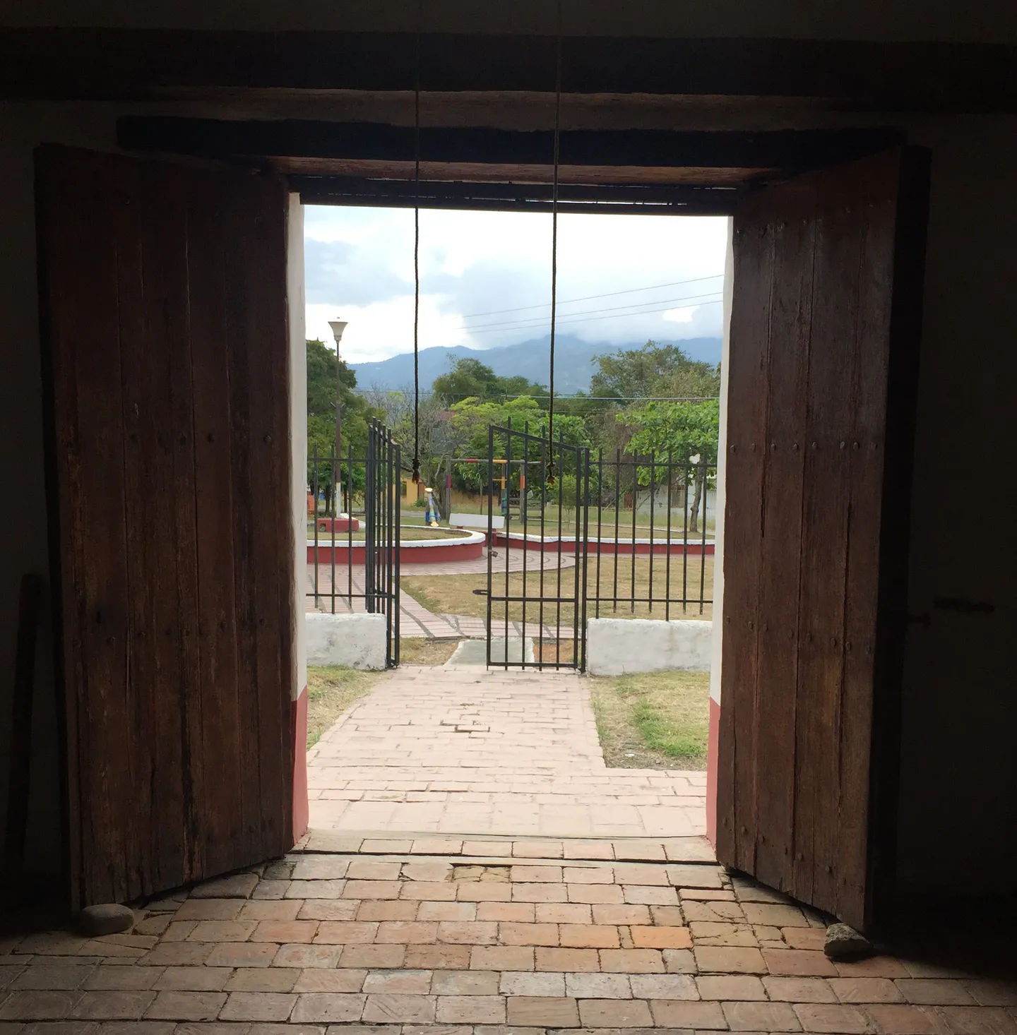 Acceso principal abierto hacia el atrio y entorno de El Bohío