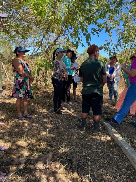 Community residents standing together outdoors discussing project plans during the technical visit.