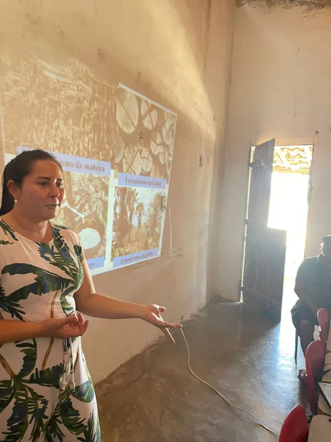 Instructor presenting projected slides illustrating different types of plant extraction such as timber and latex.