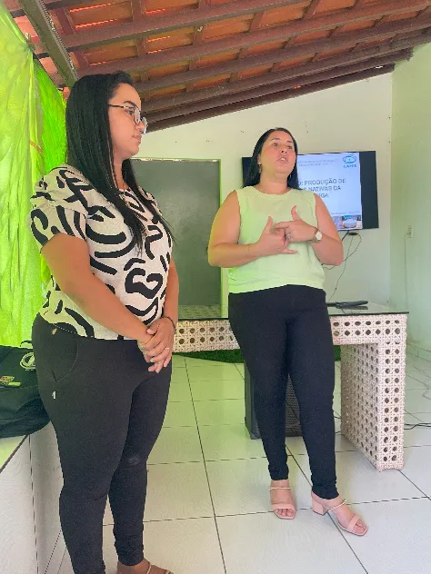 Course instructors presenting introductory slides on native seedling production in front of a television display.