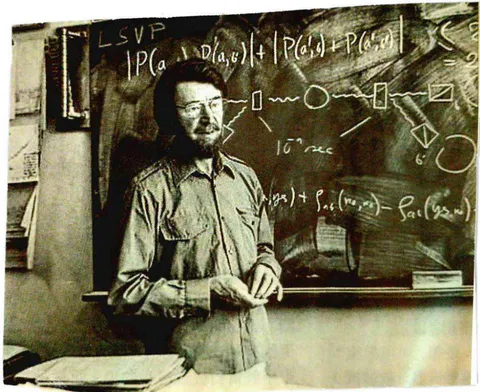 FIG. 1: Dr. J. Bell giving an academic presentation (Handwritten inequalities on the board)